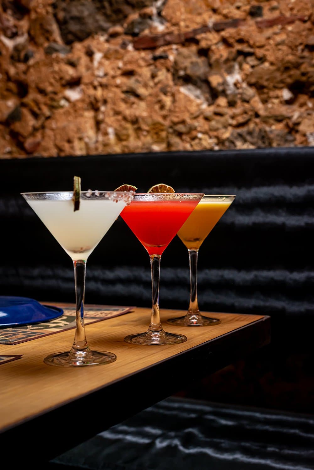 Three margaritas lined up on the bar at Las Ficheras late at night