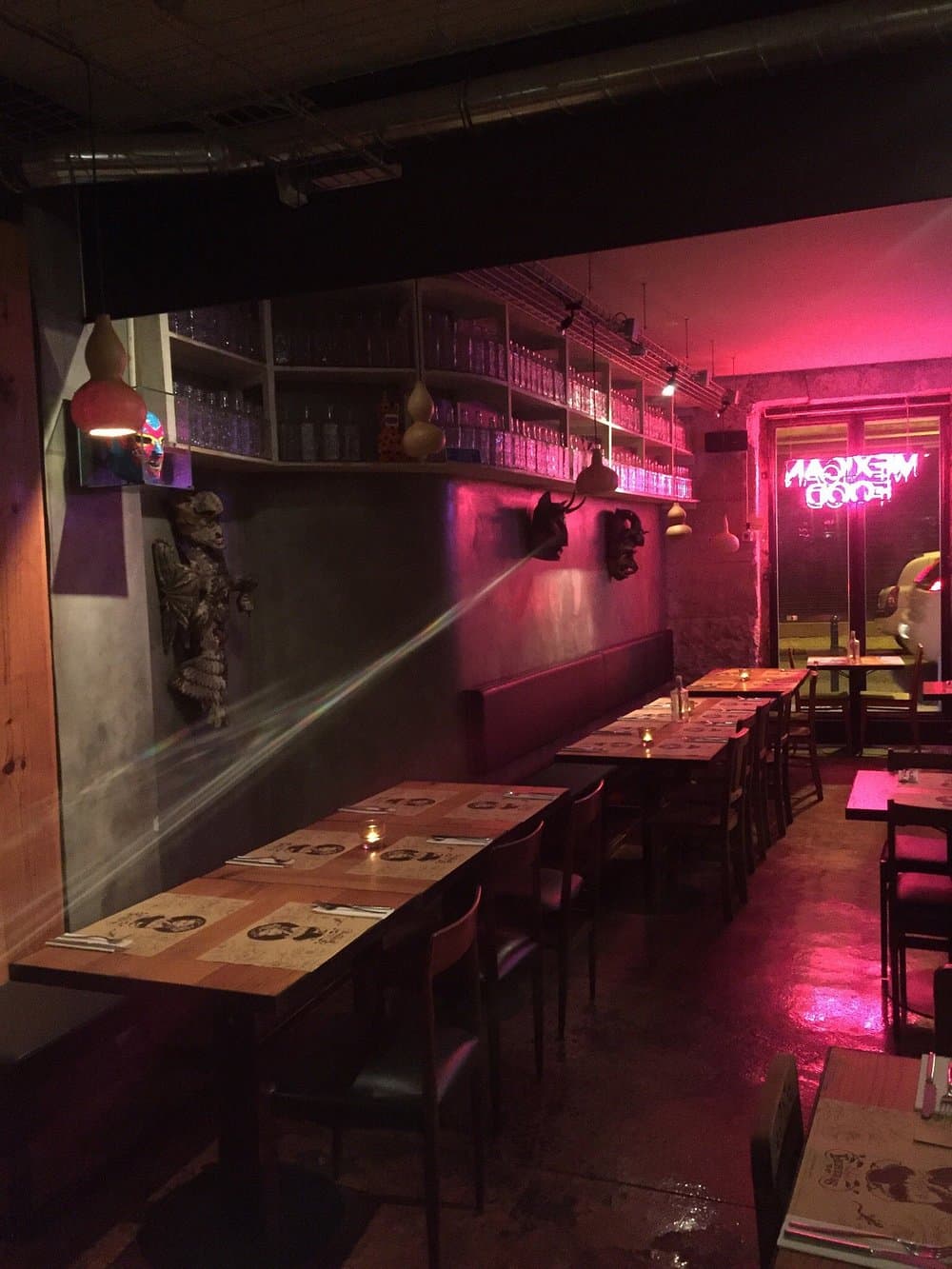 Dim, neon-lit dining room at Las Ficheras with a glowing Mexican Food sign